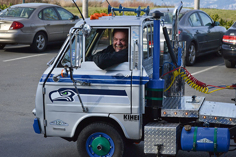 Jeff Schamel shows off his custom-painted Seahawks truck. The mini cab drags a long flatbed trailer with a goalpost on it. 